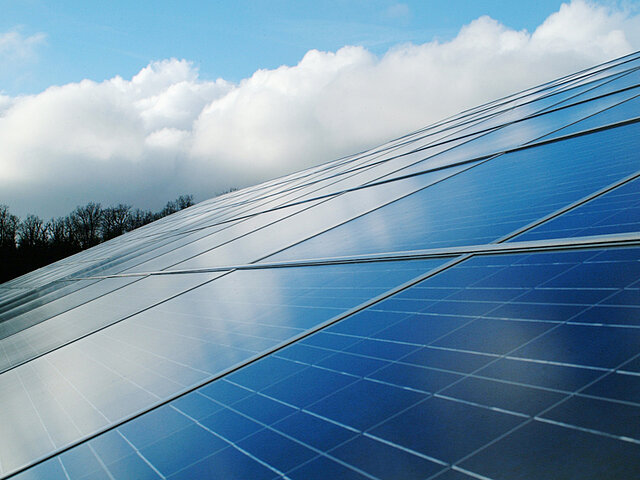 Ein großen Panel eines Solarparks glitzert in der Sonne