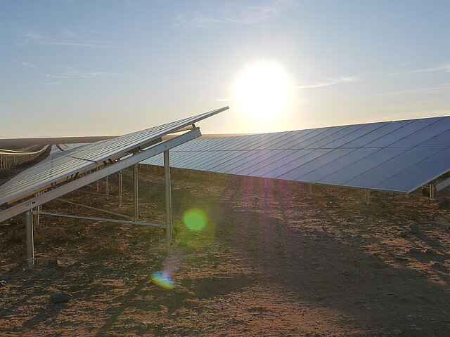 Sonnenaufgang über den Solarmodulen in Prieska. Die aufgeständerten Module scheinen fast bis zum Horizont zu reichen
