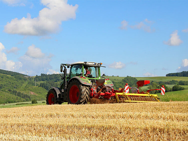 Ein Landwirt bearbeitet einen Acker. 