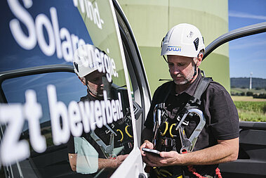 Ein JUWI-Techniker checkt seine Nachrichten auf einem Smartphone