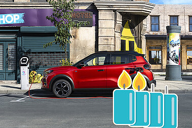 Ein E_Auto steht am Straßenrand und wird an einer Ladesäule aufgeladen. 