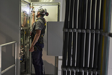 Ein JUWI-Mitarbeiter prüft das innere eines Windrads