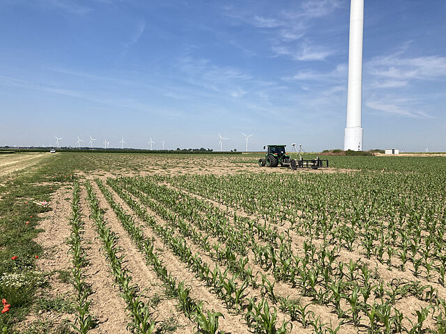 Ein Traktor fährt die Reihen eines Feldes ab und misst dabei den Boden aus.