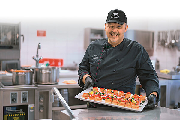 Küchenchef Jens präsentiert dekoriertes Fingerfood