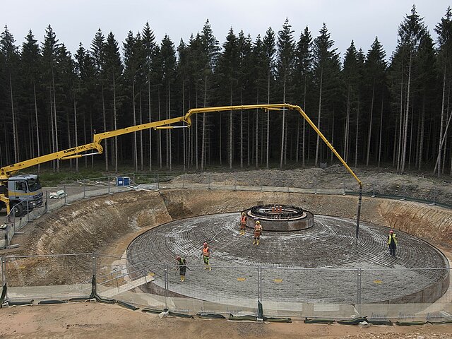 Das Fundament einer Windenergie-Anlage, dass mit Hilfe von Betonmischern befüllt wird.