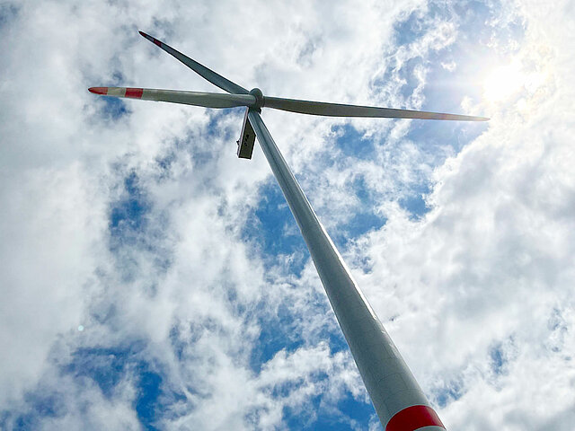 Windenergie-Anlage in Gollenberg aus der Froschperspektive. Das Windrad ragt in die Höhe.