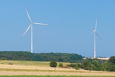 Eine Windenergie-Anlage auf einem Acker.