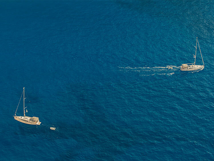 Zwei Segelboote treiben im Wasser und haben keine Segel gesetzt.