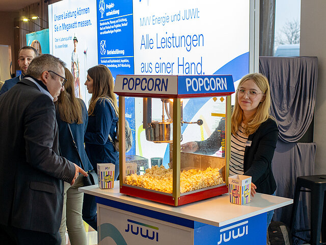 im Vordergrund steht eine Popcorn-Maschine mit JUWI-Logo, dahinter ist der JUWI-Messestand erkennbar