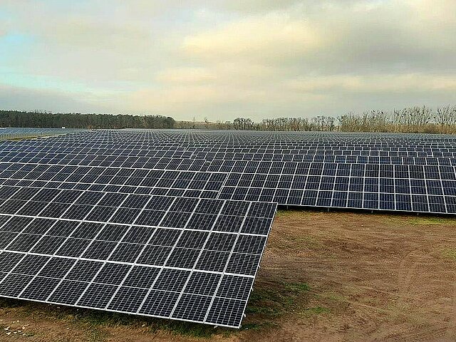 Der Solarenergiepark Metzdorf zwei bestehend aus vielen Solarkollektoren, der Himmel ist bewölkt.