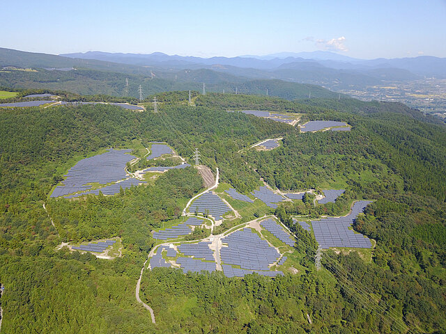 The Azuma Kofuji solar park from a bird's-eye view: The panels of the facility stand out distinctly from the surrounding trees.