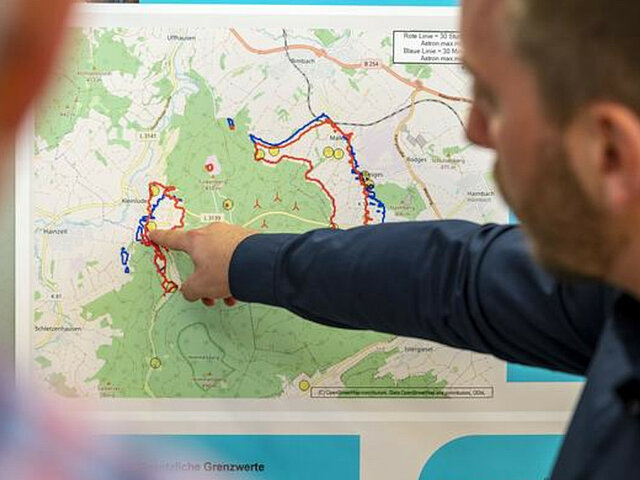 Ein JUWI-Mitarbeiter erklärt etwas auf einer Landkarte