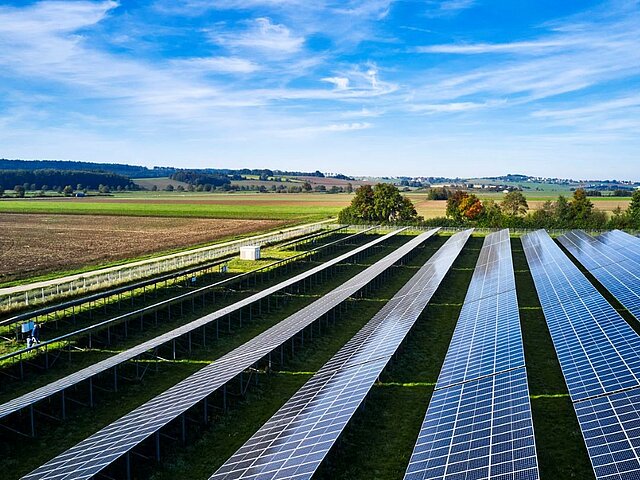 Solarpark seitlich von oben fotografiert bei gutem Wetter.