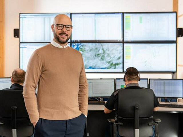Ein JUWI-Mitarbeiter der Leitwarte steht vor mehreren großen Monitoren.