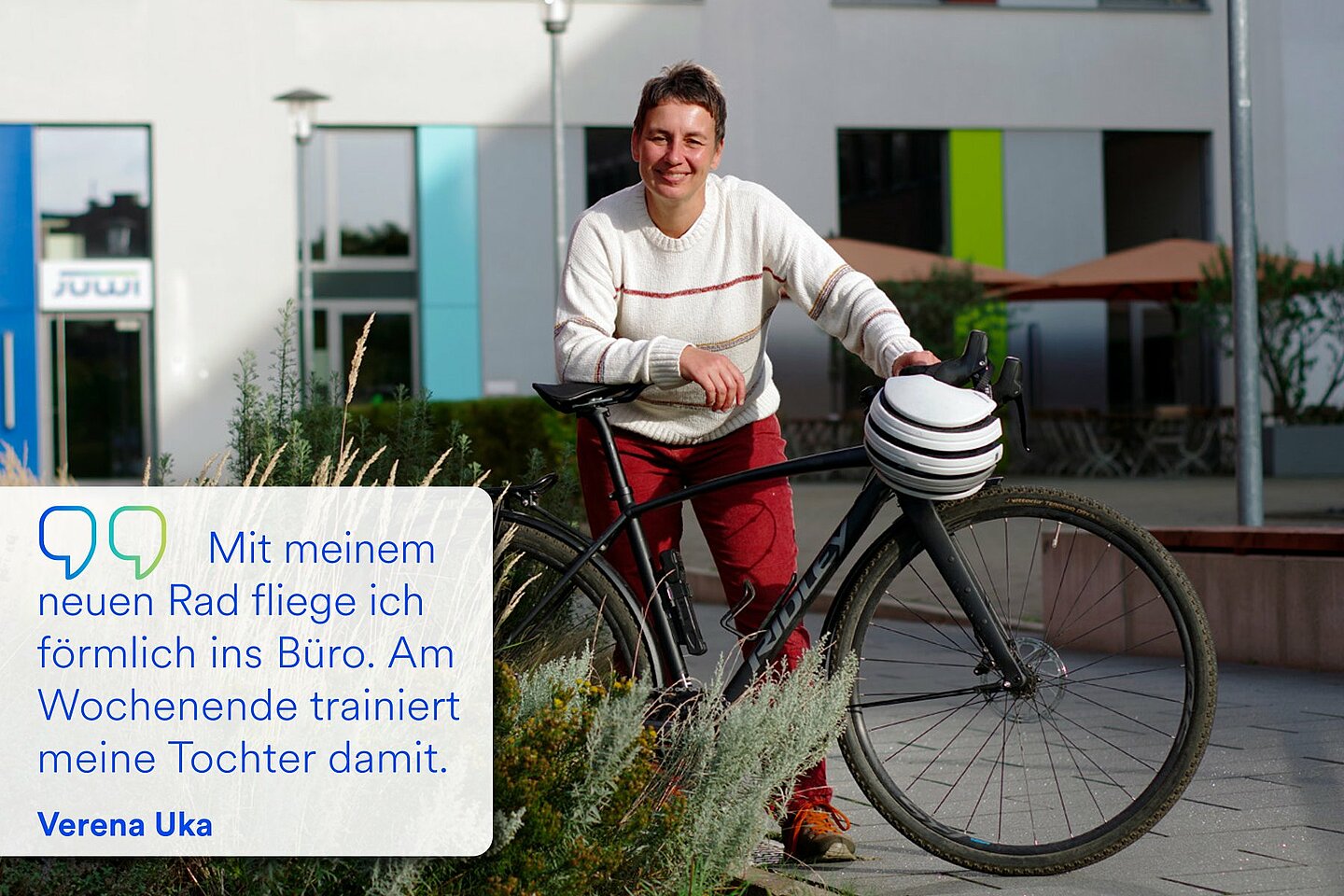 Verena Uka stützt sich lächelnd auf ihr Business-Bike.