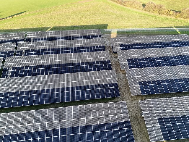 Solarpanele auf einem grünen Feld.
