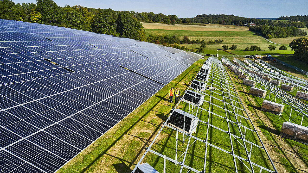 Freiflächensolarpark am Hang gebaut mit noch teils fehlenden Modulen.