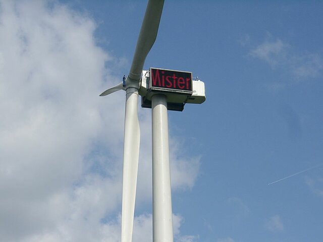 Windenergieanlage mit Displays auf denen ein Text zu sehen ist.