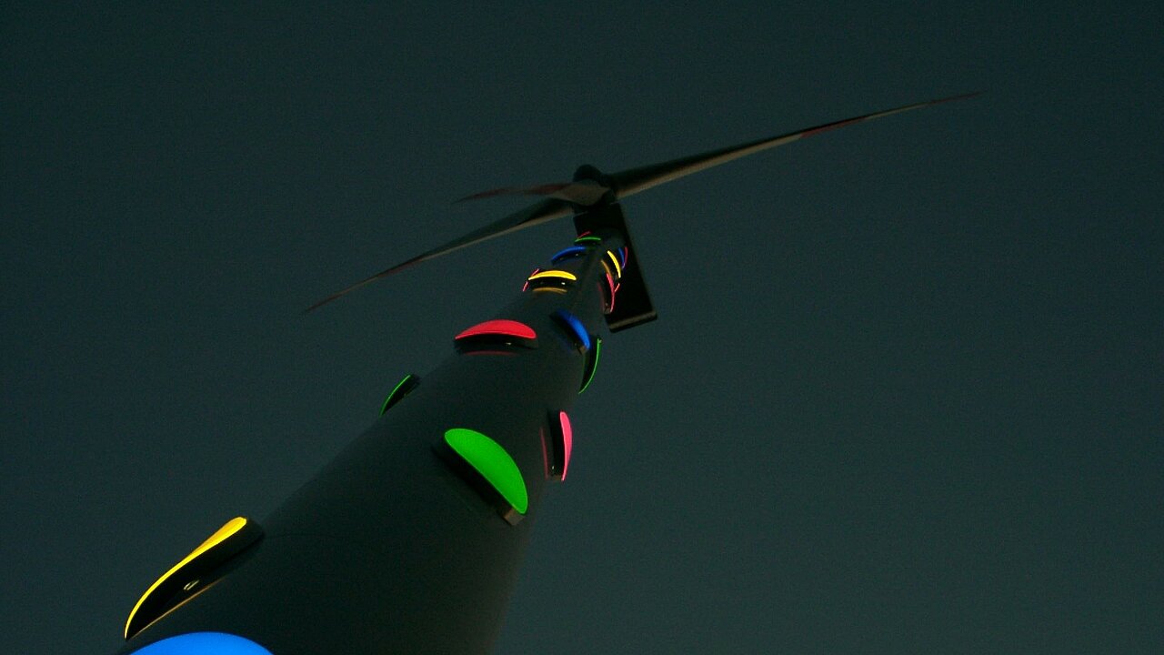 Die Windenergieanlage im Dunkeln. Die bunten Punkte leuchten.