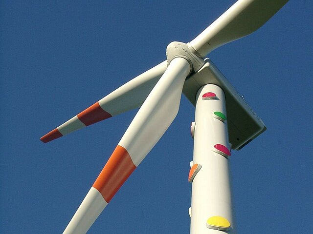 Windkraftanlage mit bunten Punkten, die im dunkeln Leuchten.