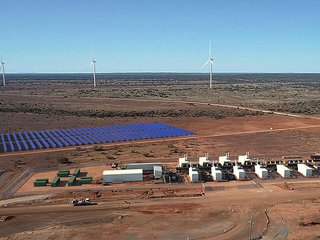 In front of the solar park, the battery storage units are clearly visible.