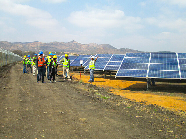 JUWI employees are discussing at a solar park.
