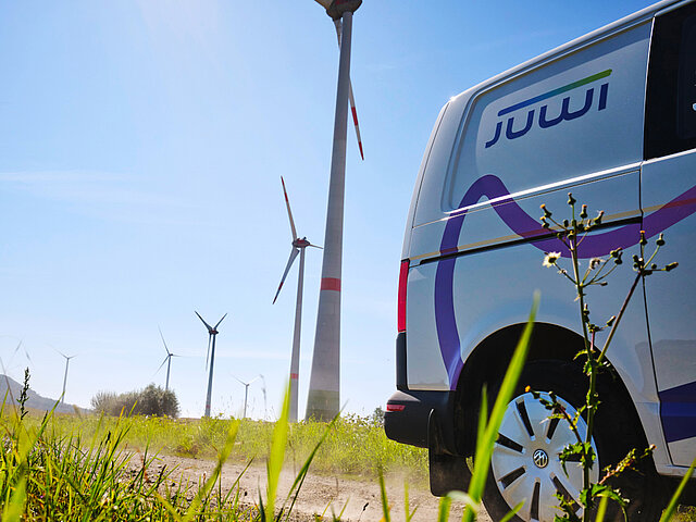 Ein JUWI-Transporter steht in einem Windpark