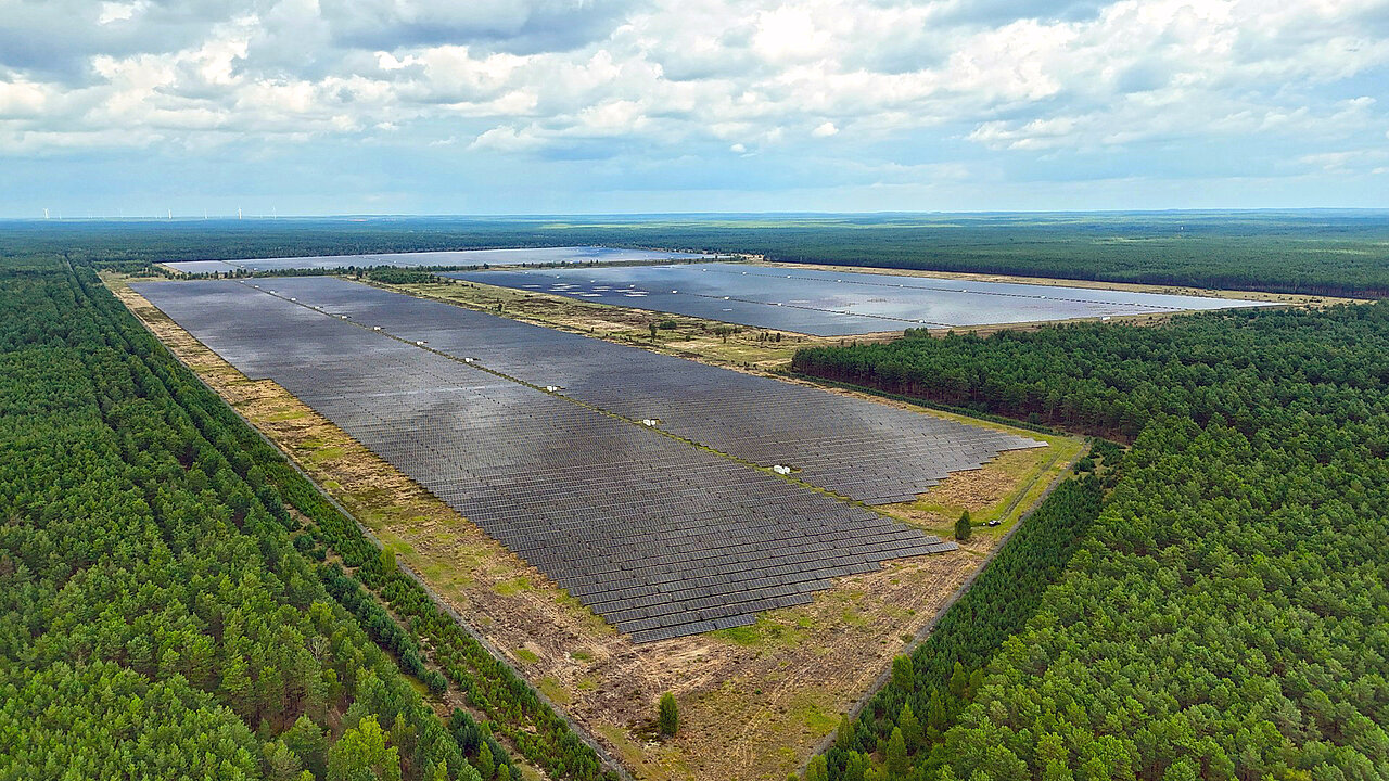 Großer Freiflächensolarpark mitten in einem großen Waldgebiet.